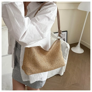 Close-up of finely woven straw texture and leather shoulder strap with metal ring details