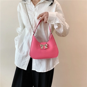 Pink hobo crossbody bag with silver butterfly knot and sleek leather finish