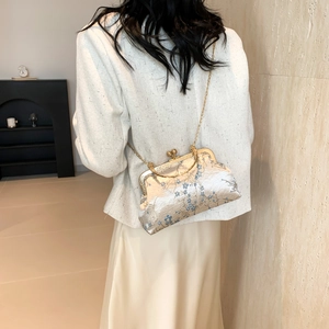 Modern shell-shaped crossbody bag with blue floral embroidery and gold chain strap