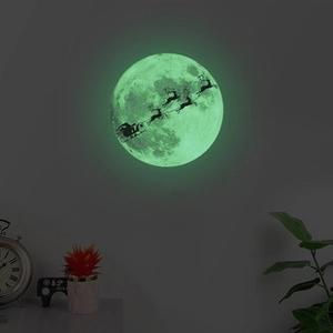 Sticker mural lumineux montrant le Père Noël sur fond de lune dans une chambre d'enfant