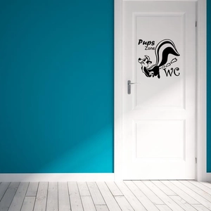 Detailed view of a funny cartoon skunk WC wall sticker on a white door in a modern bathroom