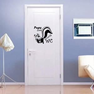 Detail of cartoon skunk PVC toilet sticker with Pups Zone WC text on a white door