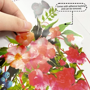 Close-up of hand peeling a watercolor floral wall sticker with self-adhesive backing