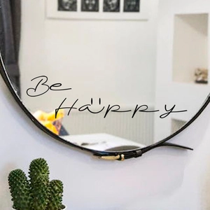 Detail of Be Happy inspirational decal with smiley face on a round bathroom mirror