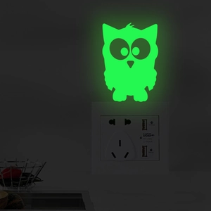 Luminous owl wall sticker glowing in the dark next to a power socket