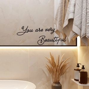 Detail shot of 'You are very Beautiful' vinyl mirror decal in a luxury bathroom