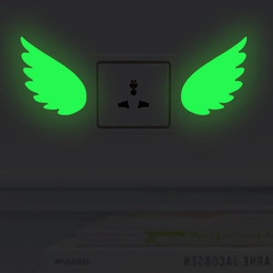 Luminous feather wings wall stickers showing a bright green glow in a dark room setting