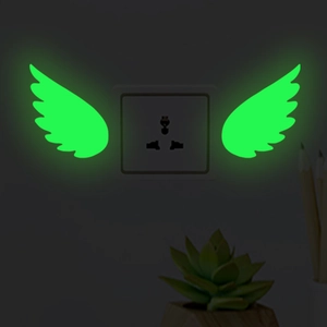 Luminous wing wall stickers glowing in the dark around a standard light switch socket