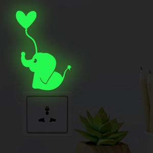Glow-in-the-dark elephant wall sticker with heart balloon decor above a power socket