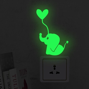 Glow-in-the-dark elephant sticker with heart balloon placed above a wall socket