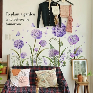 Dettaglio di adesivi murali con ortensie viola, farfalle e scritte decorative floreali