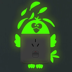 Luminous green bird wall sticker glowing around a light switch in dark bedroom