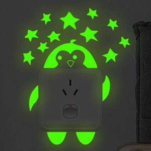 Glow-in-the-dark wall stickers featuring a luminous penguin and stars around a light switch