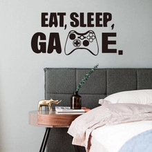 Minimalist 'EAT SLEEP GAME' wall sticker with a game controller icon in a cozy bedroom