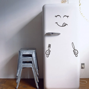 Funny kitchen fridge decal with smiley face and cutlery icons on a white vintage refrigerator