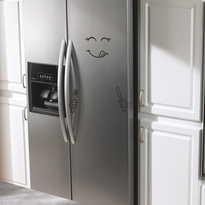 Close-up of funny minimalist smiling face with cutlery stickers on a stainless steel fridge