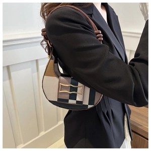 Detailansicht der karierten Achseltasche mit goldener Schnalle und Lederknotengriff