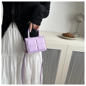 Detail of light purple quilted PU leather mini handbag with top handle and crossbody strap
