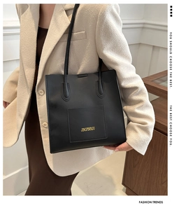 Détail du logo doré sur un grand sac cabas en similicuir noir au style professionnel