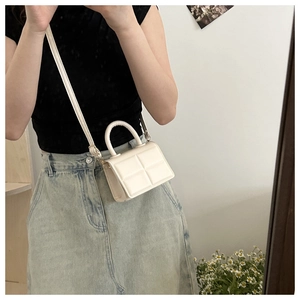 Close-up of white PU leather handbag with square embossed texture and crossbody strap