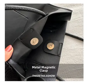 Gros plan sur la fermeture magnétique en métal et la texture cuir du sac cabas en PU noir