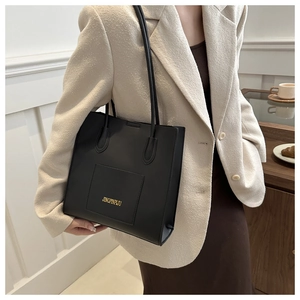 Grand cabas en cuir PU noir avec lettrage doré porté par un mannequin dans un bureau