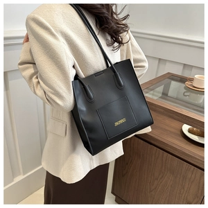Détail du sac cabas en cuir PU noir avec lettrage doré et poche avant pratique