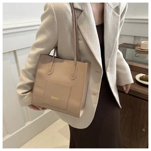 Vue détaillée du sac cabas en cuir PU beige avec bretelles élégantes et logo doré