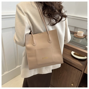 Détail d'un sac cabas en cuir PU beige avec poche avant montrant les coutures