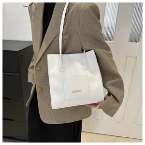 Détail du sac cabas blanc en cuir PU avec poche avant et logo aux lettres dorées