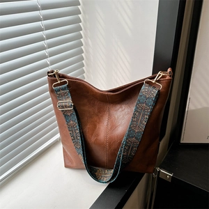 Brown faux leather hobo bag with vintage patterned wide strap and gold hardware