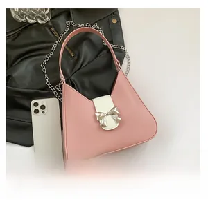 Detail of pink and white underarm bag featuring a silver bow buckle and metal chain