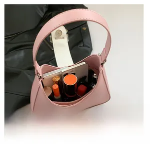 Top-down view of pale pink leather handbag interior showing storage capacity for phone and cosmetics