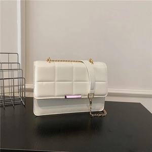 Chic white quilted crossbody bag with gold chain strap and metal lock closure