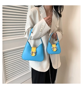 Detail of light blue saddle bag with yellow flap and silver bow metal buckle detail