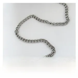Detail of a silver metal chain shoulder strap for cloud bags on white fabric