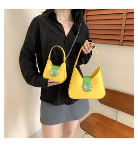 Detail of vibrant yellow crossbody bags with green straps and silver bow charms
