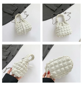 Detail view of white bubble texture bucket bag with silver chain and drawstring closure