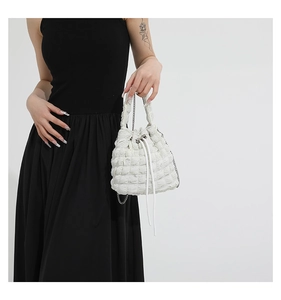 Close-up of white bubble texture fabric and silver chain strap on puffy shoulder bag