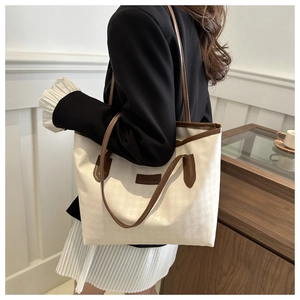 Chic beige color-block tote bag with houndstooth texture shown on model in studio