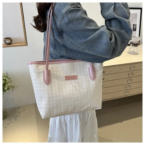 Detail of minimalist tote bag with contrast pink trim shown from a side-rear perspective