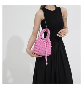 Detail of bright pink bubble texture drawstring bucket bag with silver chain strap