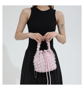 Detailed bubble texture and drawstring closure of the soft pink pleated bucket bag