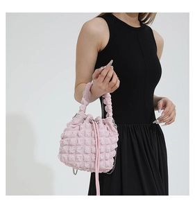 Detail of light pink popcorn texture bucket bag with drawstring and chain strap