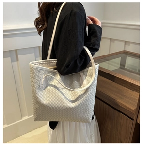 Détail d'un cabas en cuir tressé blanc avec motif en treillis élégant et étiquette mode