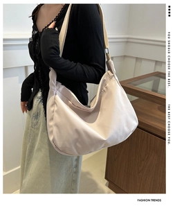 Detail view of large nylon dumpling crossbody bag with adjustable wide fabric strap