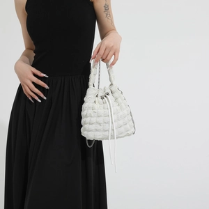 White textured puff fabric bucket bag with drawstring closure and silver chain strap
