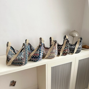 Sacs bandoulière ethniques avec bandoulière large en cinq couleurs sur un buffet blanc