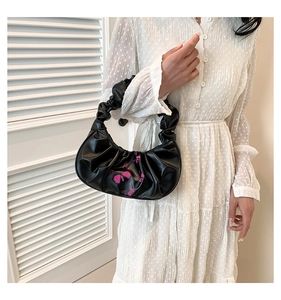 Detail of black pleated cloud bag featuring pink butterfly embroidery and soft leather