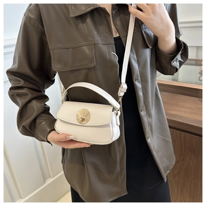 Model wearing a cream PU leather shoulder bag with a gold fan-shaped lock detail